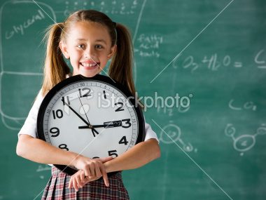 stock-photo-14626859-girl-in-a-classroom-standing-in-front-of-a-chalkboard-holding-a